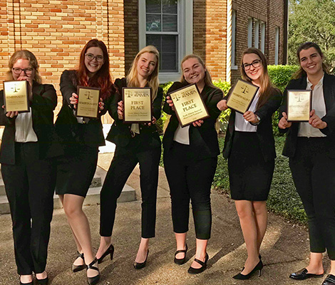 A photo of six students holding out awards